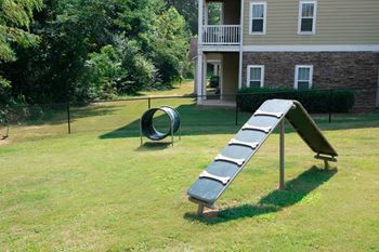 A seesaw in a yard with a house in the background